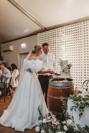 A bride and groom cut their wedding cake during the reception at Burnham Grove