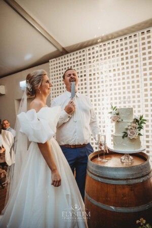 A groom licks the knife after cutting their wedding cake