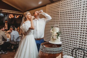 A bride and groom share a toast after cutting their wedding cake