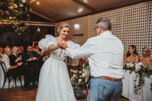 A bride shares a first dance with her father during the wedding reception