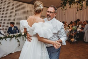 A bride shares a first dance with her father during the wedding reception