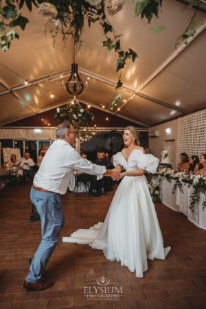 A bride shares a first dance with her father during the wedding reception