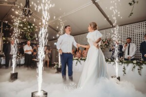 A bride and groom share their first dance surrounded by fireworks and dry ice fog