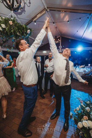 A groom high fives a guest during the wedding reception