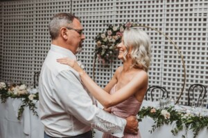 A bridesmaid dances with her father during the wedding reception