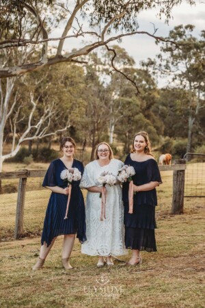 A bridal party stand on the lawn of Ottimo House at sunset