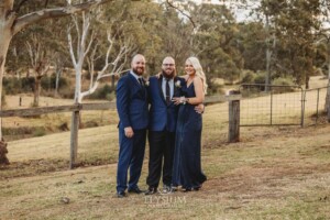 A bridal party stand on the lawn of Ottimo House at sunset