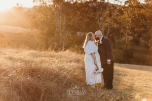 A bride and groom share a kiss on the hilltop behind Ottimo House after their wedding