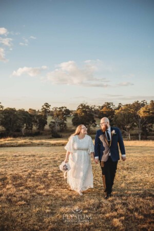 A married couple walk on the Ottimo House hilltop after their wedding at sunset