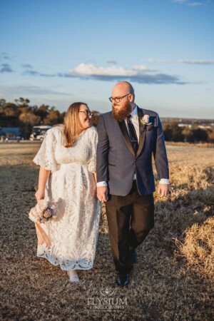 A married couple walk on the Ottimo House hilltop after their wedding at sunset