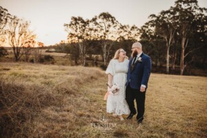 A married couple walk on the Ottimo House hilltop after their wedding at sunset