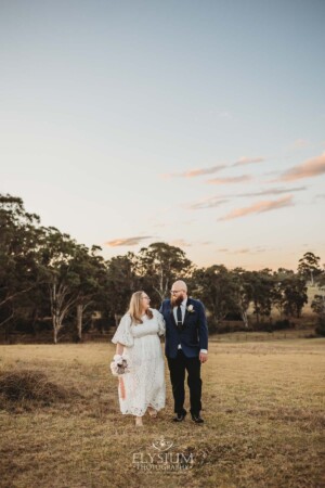 A married couple walk on the Ottimo House hilltop after their wedding at sunset