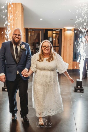 A bride and groom enter their wedding reception at Ottimo House