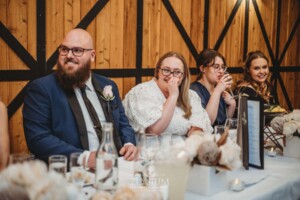 A couple laugh at wedding speeches during the reception