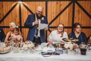 A couple laugh at wedding speeches during the reception