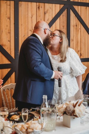 A bride and groom kiss after cutting their wedding cake