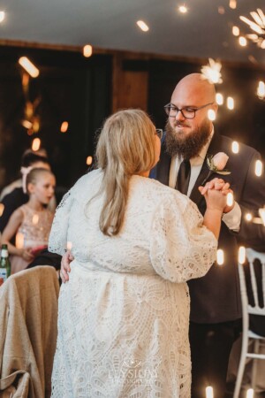 A bride and groom share their first dance surrounded by sparklers