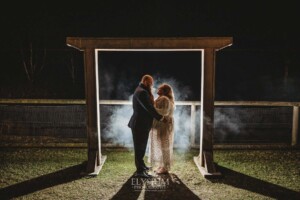 Night photos of a bride and groom under their wedding arbor at Ottimo House
