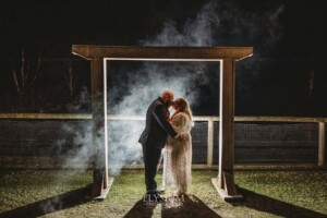 Night photos of a bride and groom under their wedding arbor at Ottimo House