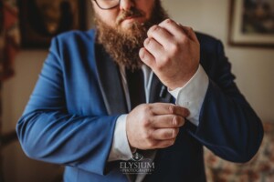 A groom adjusts his cufflinks in preparation for his wedding
