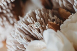 A wedding ring sits in a flower of a bridal bouquet