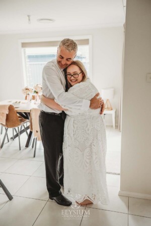 A father catches his first glimpse of his daughter in her wedding gown and hugs her