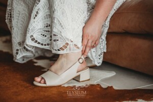 A bride adjusts her wedding shoes before leaving to the ceremony