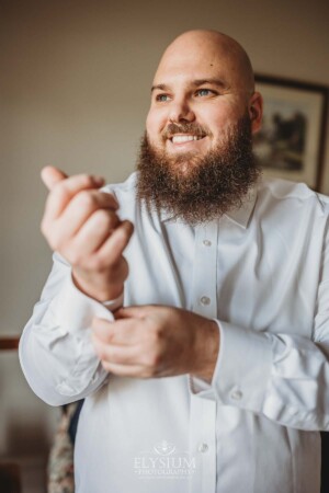 A groom adjusts his cufflinks in preparation for his wedding