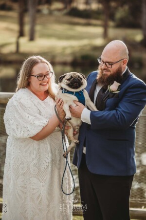 A couple stand with their pug dog after their Ottimo House wedding