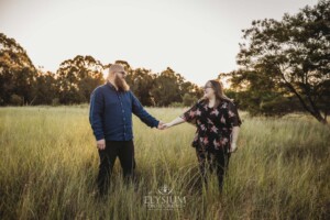 An engagement session with a couple in a grassy field at sunset