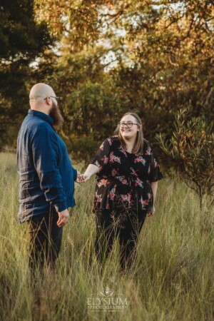 An engagement session with a couple in a grassy field at sunset