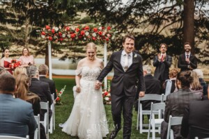 A bride and groom walk back down the aisle after being officially announced at the wedding ceremony