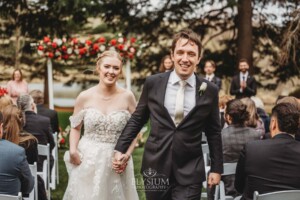 A bride and groom walk back down the aisle after being officially announced at the wedding ceremony