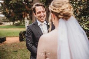 A groom smiles as he sees his bride for the first time during their private first look