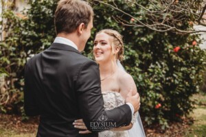 A groom smiles as he sees his bride for the first time during their private first look