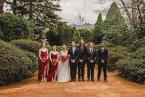 The bridal party pose for pictures on the dirt driveway at Bendooley Estate after a wedding