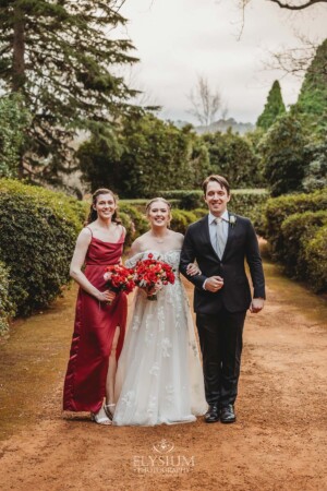 The bridal party pose for pictures on the dirt driveway at Bendooley Estate after a wedding