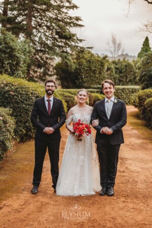 The bridal party pose for pictures on the dirt driveway at Bendooley Estate after a wedding