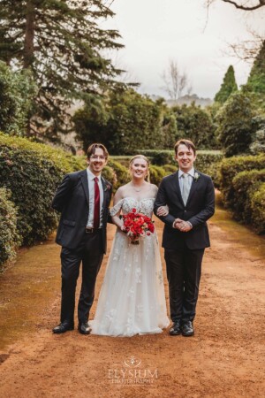 The bridal party pose for pictures on the dirt driveway at Bendooley Estate after a wedding