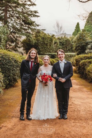 The bridal party pose for pictures on the dirt driveway at Bendooley Estate after a wedding