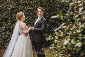 A groom smiles as he sees his bride for the first time during their private first look