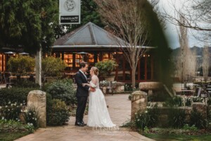 A bride and groom stand in front of the Bendooley Book Barn before their wedding reception begins