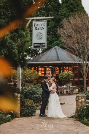 A bride and groom stand in front of the Bendooley Book Barn before their wedding reception begins