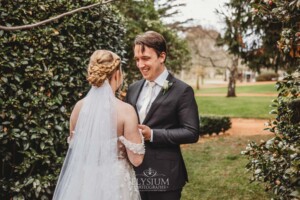 A groom smiles as he sees his bride for the first time during their private first look