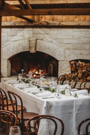 Wedding details showing the table settings in front of an open fireplace