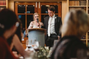 A bride and groom share their wedding speech during the reception