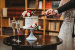 A bride and groom cut into their wedding cake during the reception at Bendooley Book Barn