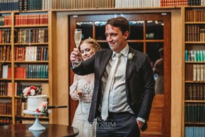 A bride and good share a toast after cutting their wedding cake