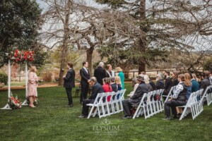 A groom awaits his bride standing at the front of the wedding ceremony