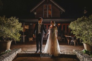 Newlyweds stand outside the Bendooley book barn at night